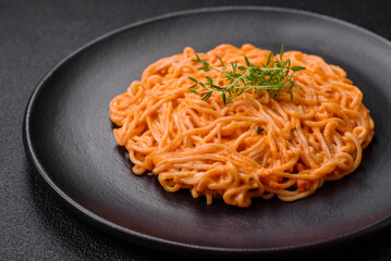 Delicious fresh pasta consisting of thin noodles, red pesto rosso sauce with spices and herbs