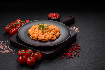 Delicious fresh pasta consisting of thin noodles, red pesto rosso sauce with spices and herbs