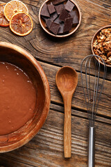 Bowl with dough and ingredients for preparing chocolate brownie on wooden background