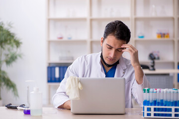 Young male chemist working at the lab