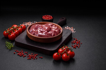 Fresh raw chicken or turkey liver in a ceramic plate with salt, spices and herbs