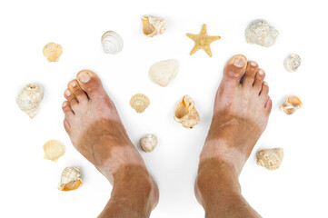 Tanned man's feet with seashells on white background. Vacation card