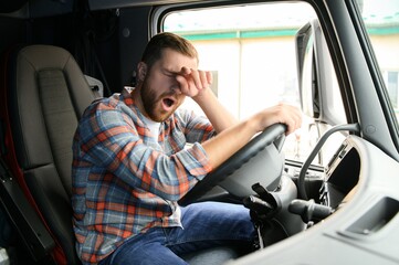 Young truck diver feeling tired and yawning during the ride.