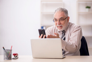 Old male employee working in the office