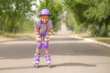 Fototapeta premium Funny laughing liberated girl rides roller skates. Protective sports accessories for extreme sports