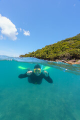 split shot of a girl doing snorkel with stinger suit