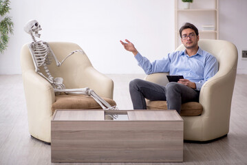 Young male psychologist meeting with skeleton