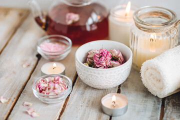Fototapeta na wymiar Aromatherapy. Organic natural floral, plant ingredients for spa treatment in salon. Rose petals, essential oil, burning candles, towels, delicious herbal tea, Atmosphere of relax, detention.