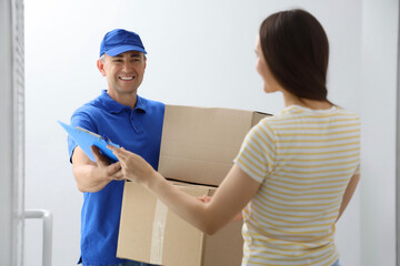 Young woman receiving parcels from courier in stairway