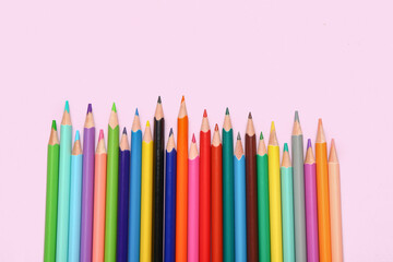 Group of colorful pencils on light pink background
