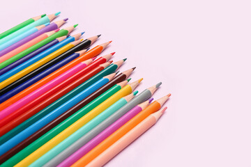 Group of colorful pencils on light pink background