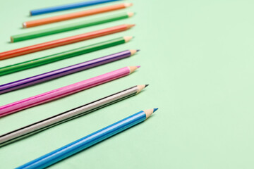 Group of colorful pencils on light green background