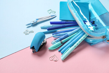 Pencil case with different school stationery on color background, closeup