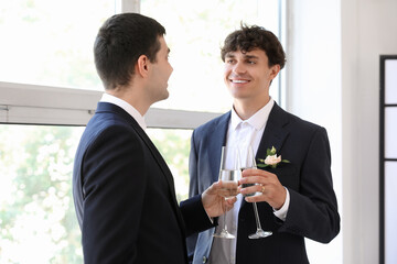 Happy gay couple with glasses of champagne on their wedding day