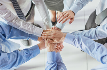 Top view shot of stack of hands. Young college students putting their hands on top of each other symbolizing unity and teamwork.