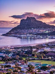 Fototapeten Aerial vertical shot of Hout Bay town, harbour, mountain and the beach during sunset, Western Cape, South Africa © Arnold