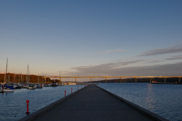Fototapeta na wymiar Outdoor exterior view at Vejle Havn Mole and background of Vejle Fjord Bridge during twilight sky in Vejle, Denmark. 