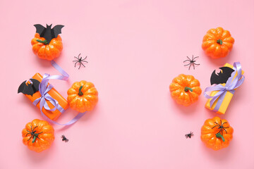 Composition with pumpkins, gift boxes, paper bats and spiders on pink background. Halloween celebration concept