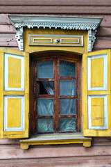 Decorated with ornamental carvings windows with shutters, frames on vintage wooden rural house in Irkutsk,Russia. Russian traditional national folk style in wooden architecture. Countryside. Landmark