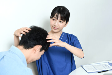 Fototapeta premium 薄毛治療の診断をする医師と男性患者 