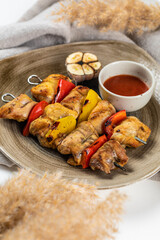 Grilled meat on a wooden board with trimmings on a light background