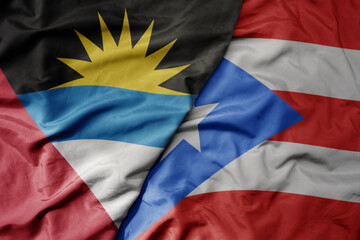 big waving realistic national colorful flag of antigua and barbuda and national flag of puerto rico .