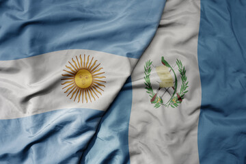 big waving realistic national colorful flag of argentina and national flag of guatemala .