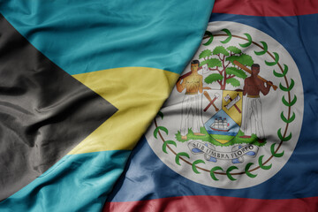 big waving realistic national colorful flag of bahamas and national flag of belize .