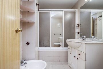 Fototapeta na wymiar Old and very worn bathroom with sink cabinet
