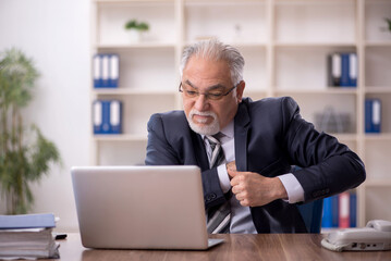 Old male employee working in the office