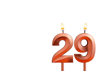 Burning candle number 29 for birthday on white background