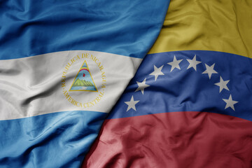 big waving realistic national colorful flag of nicaragua and national flag of venezuela .