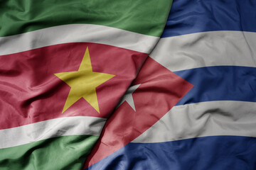 Fototapeta premium big waving realistic national colorful flag of suriname and national flag of cuba .