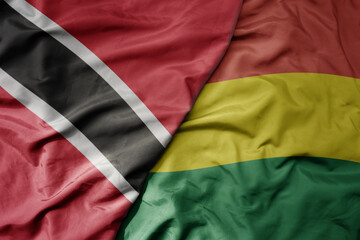big waving realistic national colorful flag of trinidad and tobago and national flag of bolivia .