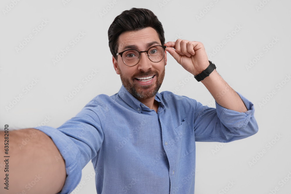 Canvas Prints Smiling man taking selfie on white background