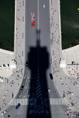 Shadow cast by the Eiffel Tower Paris falls onto the bridge with boats on the river Seine - obrazy, fototapety, plakaty