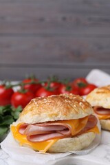 Delicious bagel with ham and cheese on table. Space for text