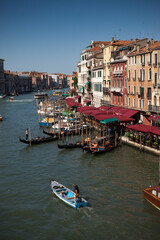 View from the Rialto Bridge of the Grand Canal (Canal Grande) with boats and Gondola.