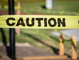 Yellow caution tape with black lettrs at construction site marking the presence of a trench