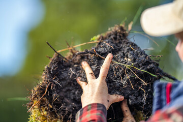 female farmer holding soil looking at soil carbon