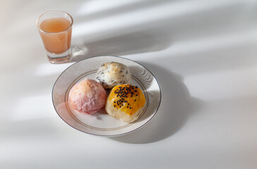 Pastries on a plate and a glass of tea on the table against the light of the morning window.