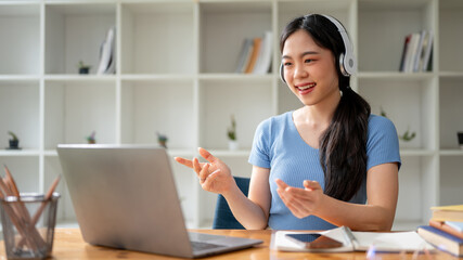 A smart Asian female college student having an online class or online meeting at home
