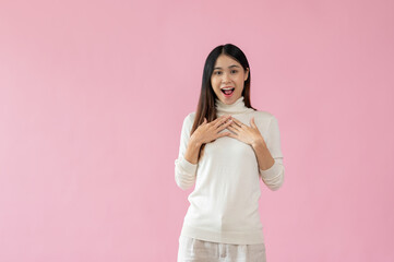 An attractive Asian woman hands touching her chest with a happy, excited face, surprised