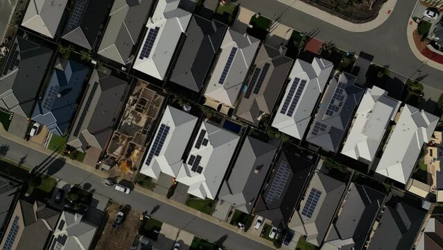 Solar panels on private houses roofs of Perth city in Australia. Aerial top down forward