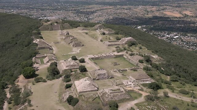 Aerial slowly orbits ancient hilltop Zapotec site of Monte Alban, MX