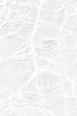 White water with ripples on the surface. Defocus blurred transparent white colored clear calm water surface texture with splashes and bubbles. Water waves with shining pattern texture background.