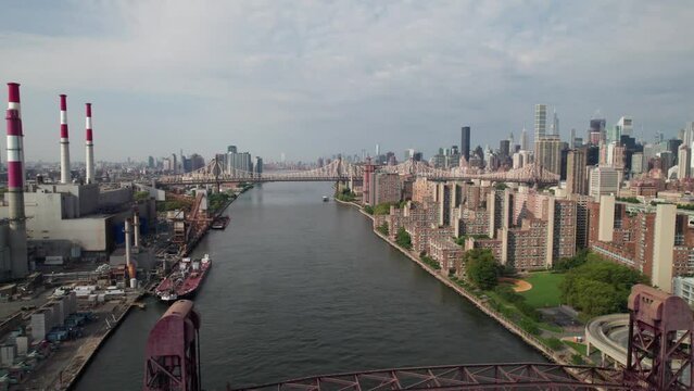 New York's East River with bridges, factories, Roosevelt Island, 4K drone shot.