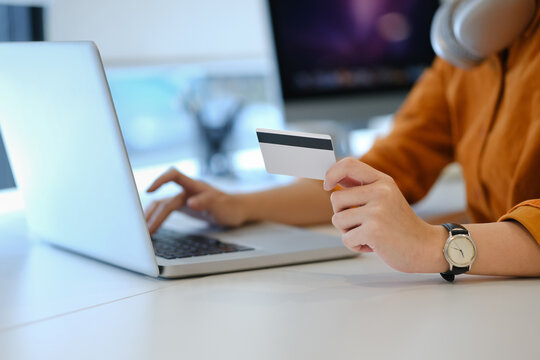 Shot of Shopping online concept, Office woman holding credit card and using laptop computer.