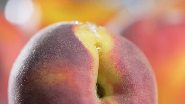Water drop falling of nectarine surface in slow motion, macro shot