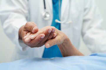 Doctor holding hands Asian elderly woman patient, help and care in hospital.